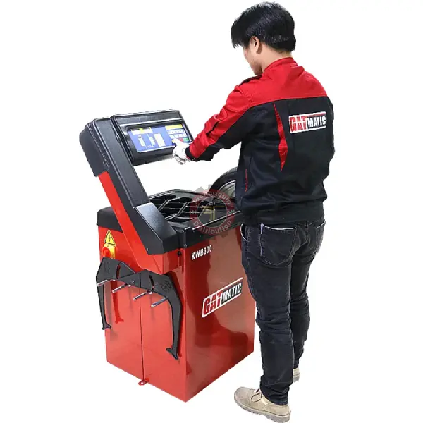 Équilibreuse GATMATIC KWB300 utilisée par un technicien en atelier