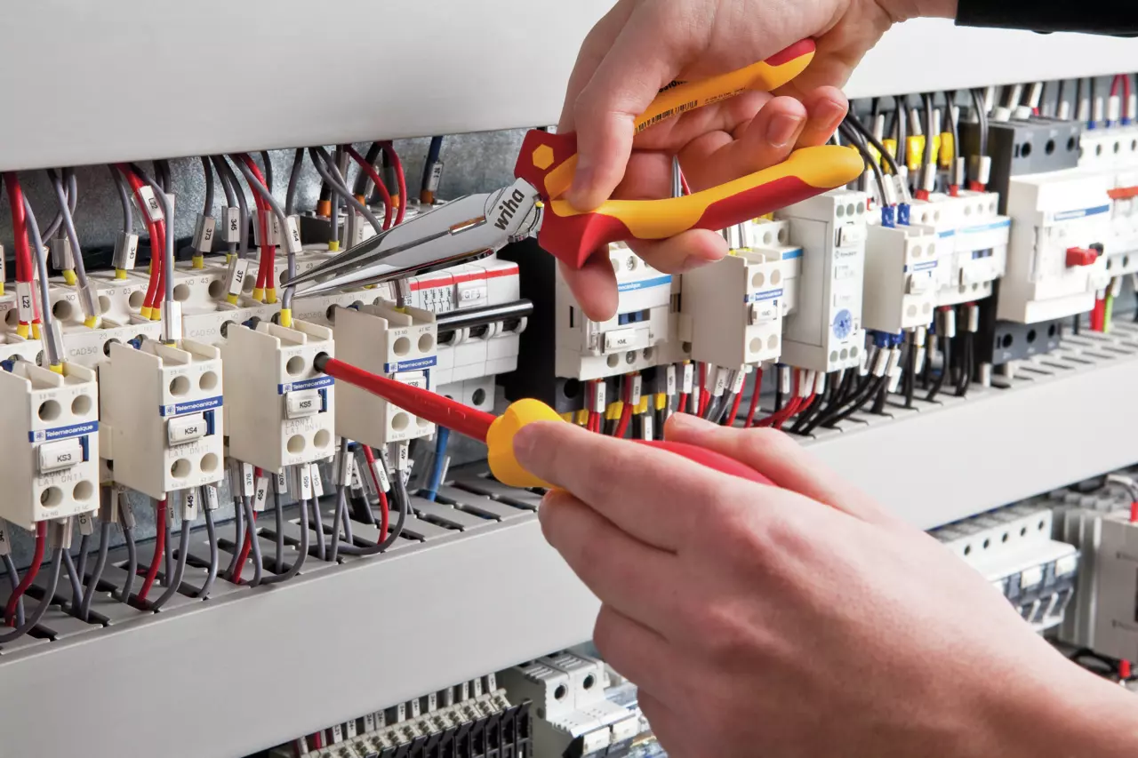 Travail sur un composant en profondeur dans une armoire de commande avec la pince demi-ronde Professional electric 200 mm du jeu isolé Wiha 26852